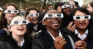 Students looking up toward a solar eclipse with glasses